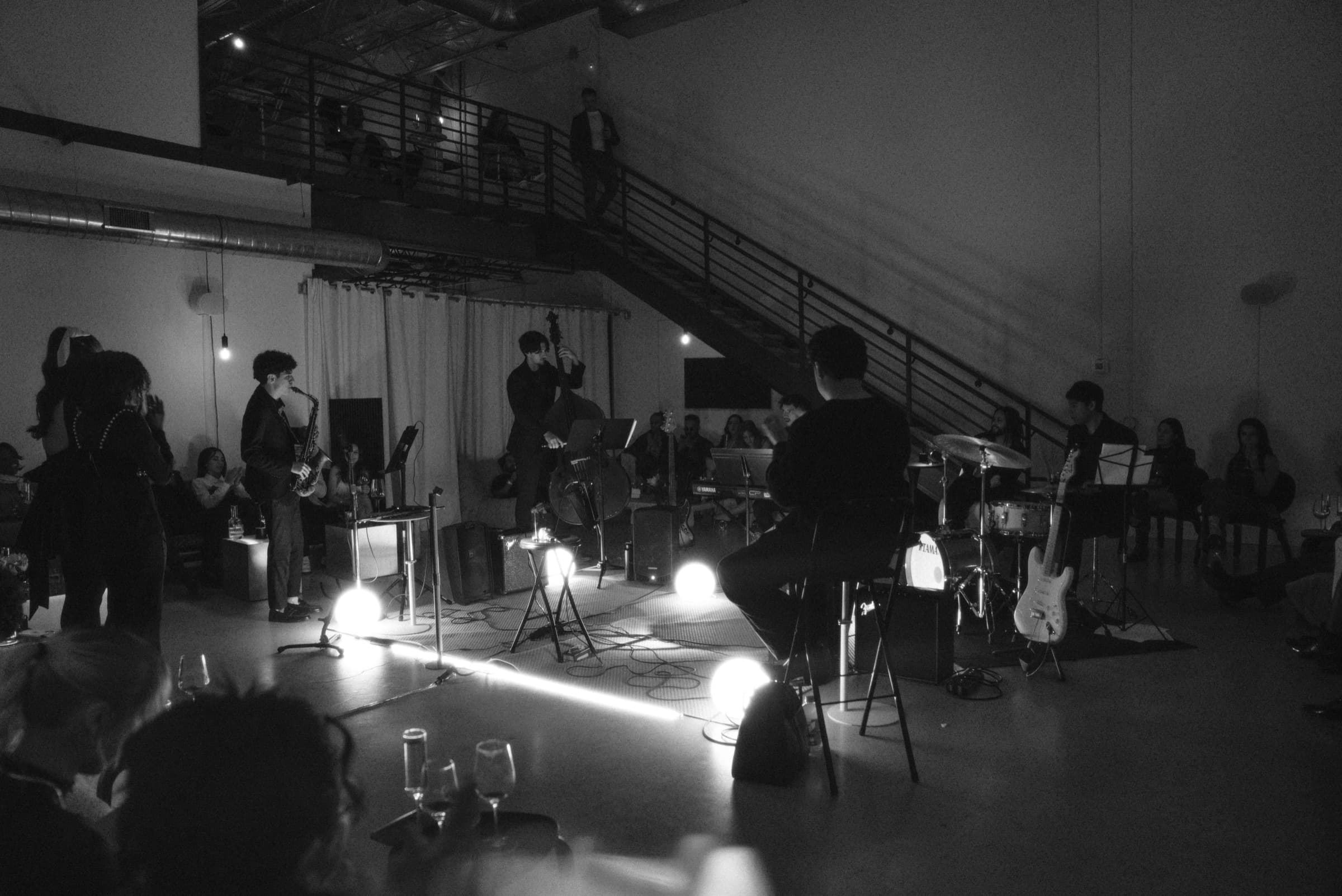 The room applauding at the end of a number, the band still lit on the floor.